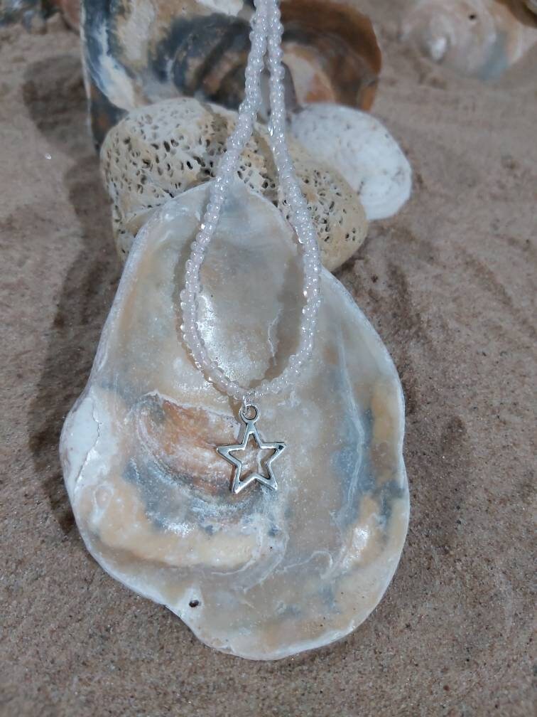 Star charm on a dainty seed bead anklet.