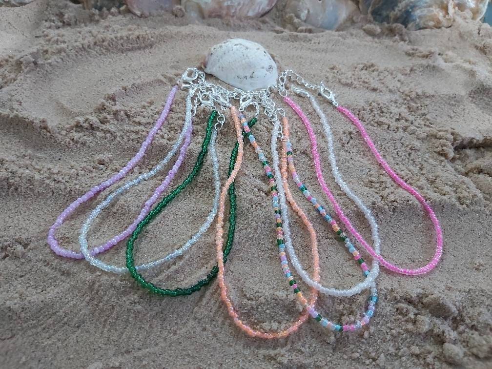 Foot print , feet charm on a dainty seed bead anklet. Anklet is adjustable with a silver plated chain.